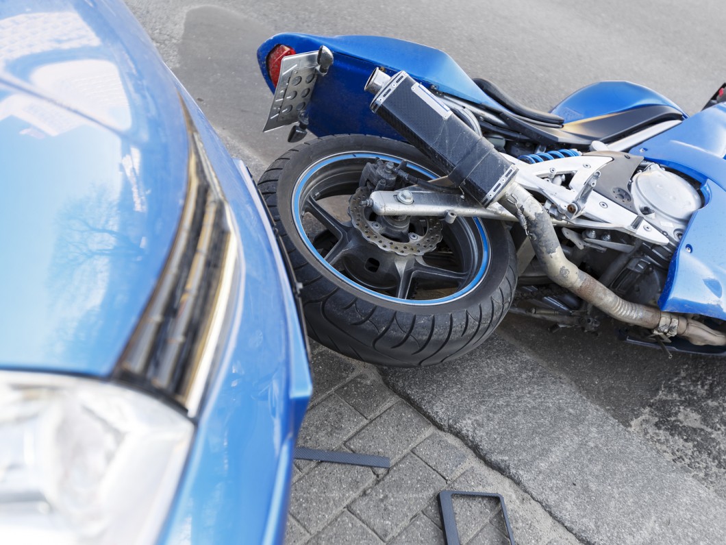 blue car and blue motorcycle toppled over