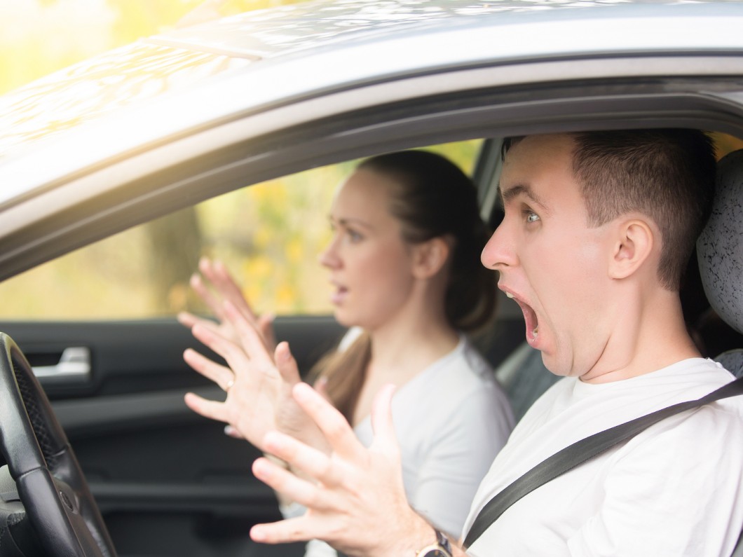 man and woman wearing white in a car and screaming