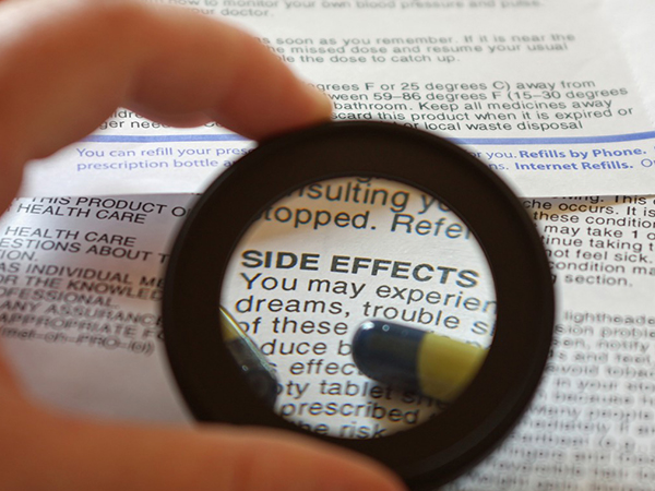 person reading side effects with a magnifying glass