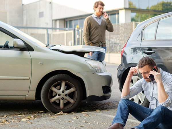 aftermath of car accident with two men on their cell phones